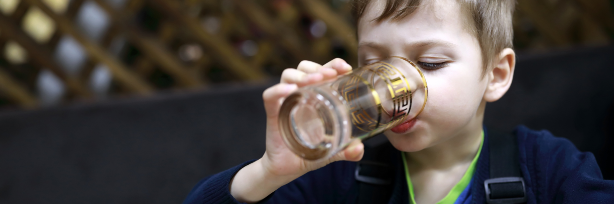 Barn drikker vand fra glas