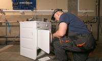 Mand reparerer tørretumbler