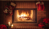 Ild i pejs med julepynt rundt om pejsen